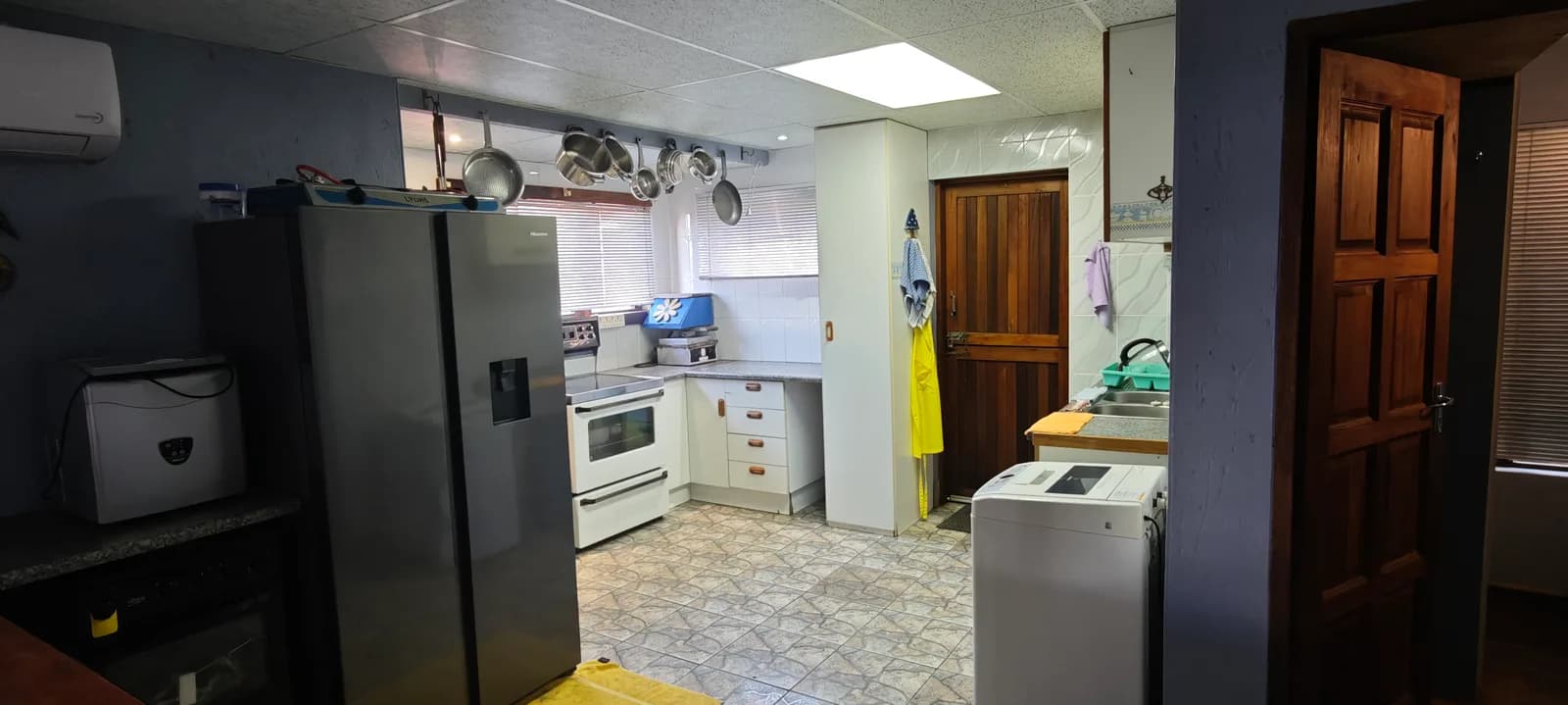 Kitchen with a large fridge-freezer, electric stove and washing machine